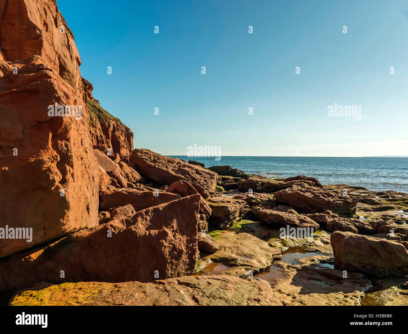 Beautiful rustic rock formation at low tide along the Jurassic Coast between the seaside town of Exmouth and Sandy Bay, Devon. Stock Photo