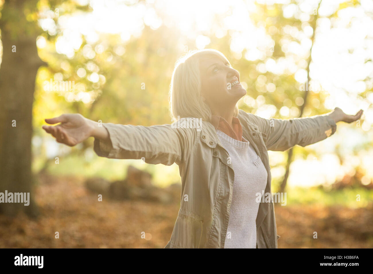 Mature woman with arms outstretched in forest Stock Photo - Alamy
