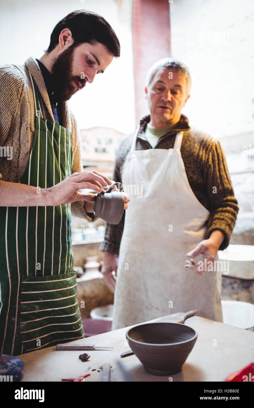 Potters working while standing at table Stock Photo Alamy
