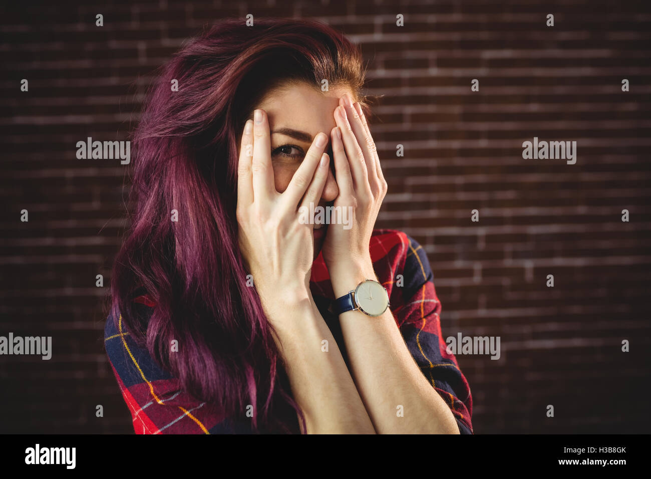 Young woman hiding face behind hands Stock Photo