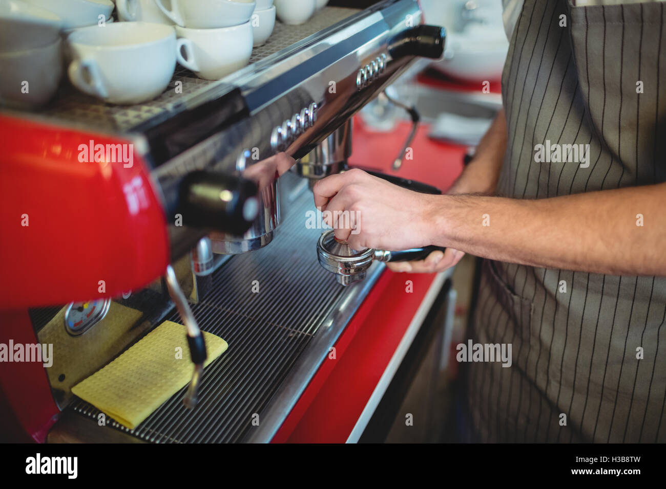 Midsection of waiter with strainer at cafe Stock Photo