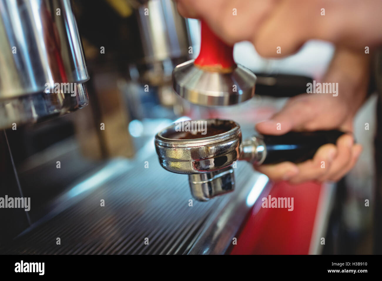 Cropped image of waiter with strainer at coffee shop Stock Photo