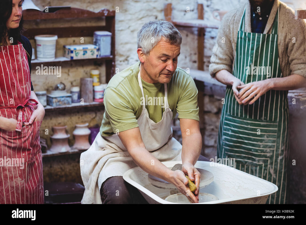 Male artist with colleagues in pottery workshop Stock Photo - Alamy