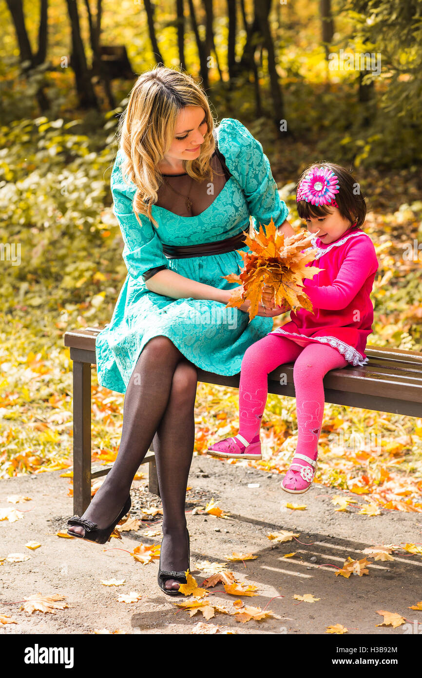 Young mother playing with her daughter in autumn park Stock Photo - Alamy