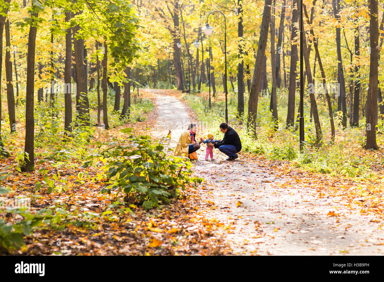 Happy family playing in autumn park Stock Photo - Alamy
