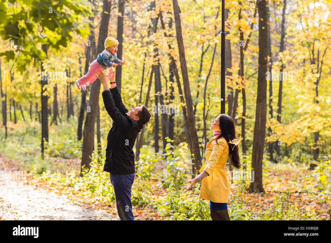 Happy family playing in autumn park Stock Photo - Alamy