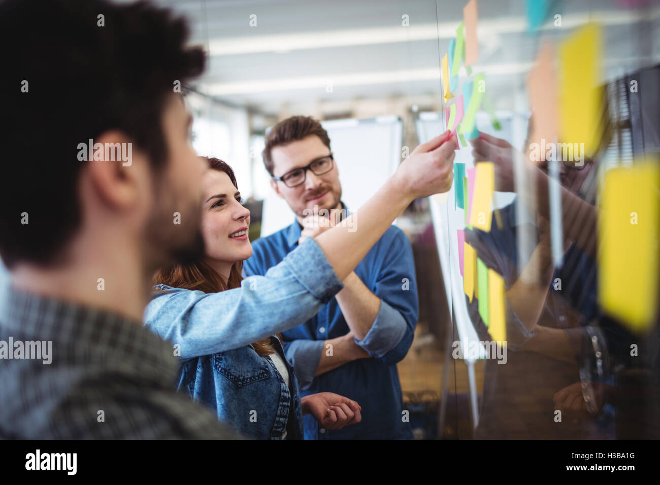 Smiling businesswoman writing on sticky notes Stock Photo - Alamy