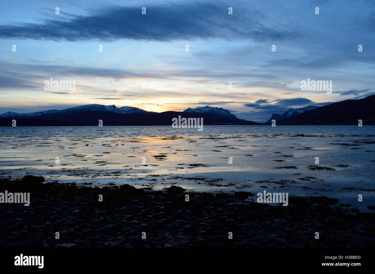 beautiful sunset over snowy mountain range and calm blue fjord Stock ...