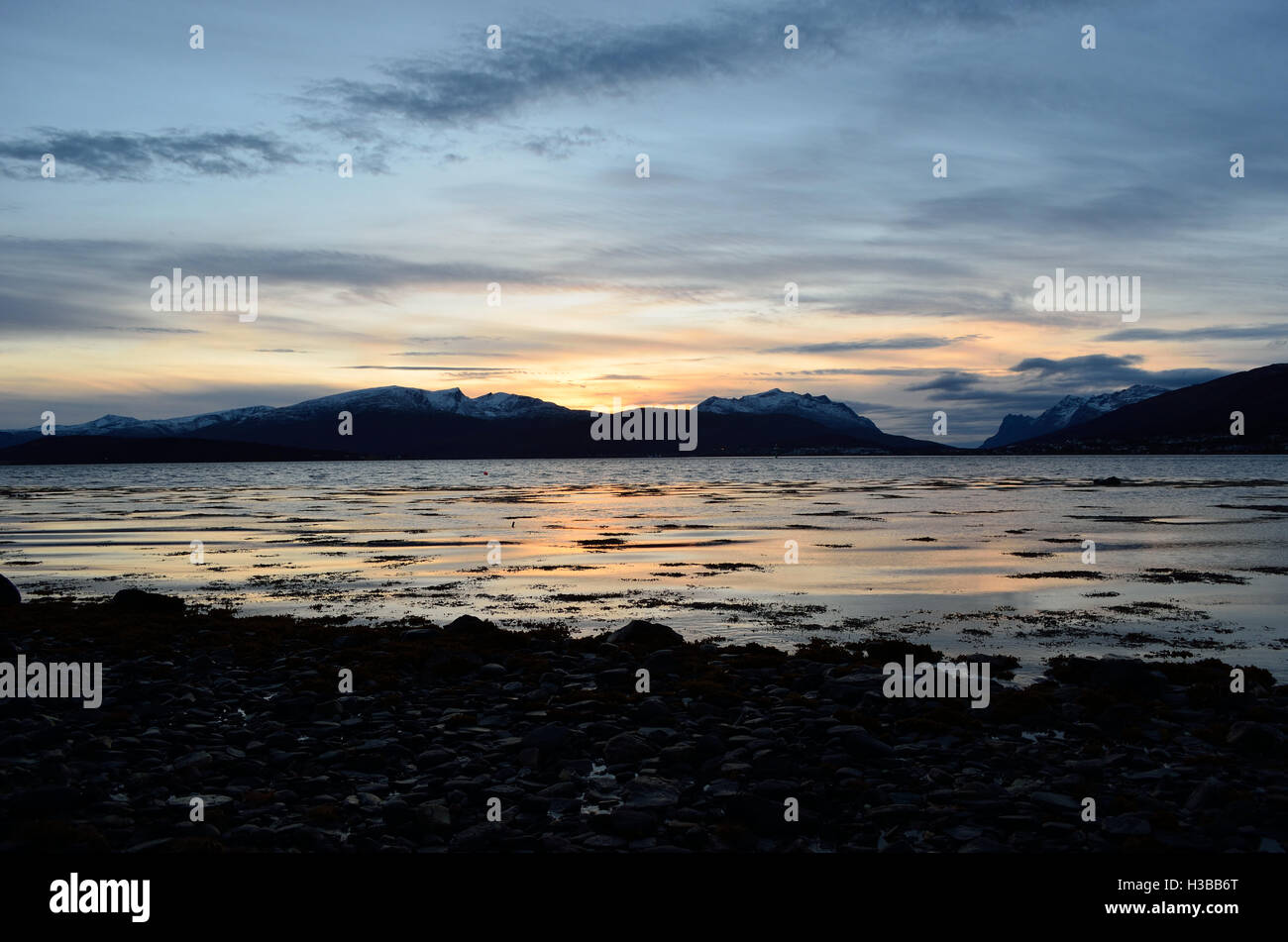 beautiful sunset over snowy mountain range and calm blue fjord Stock ...