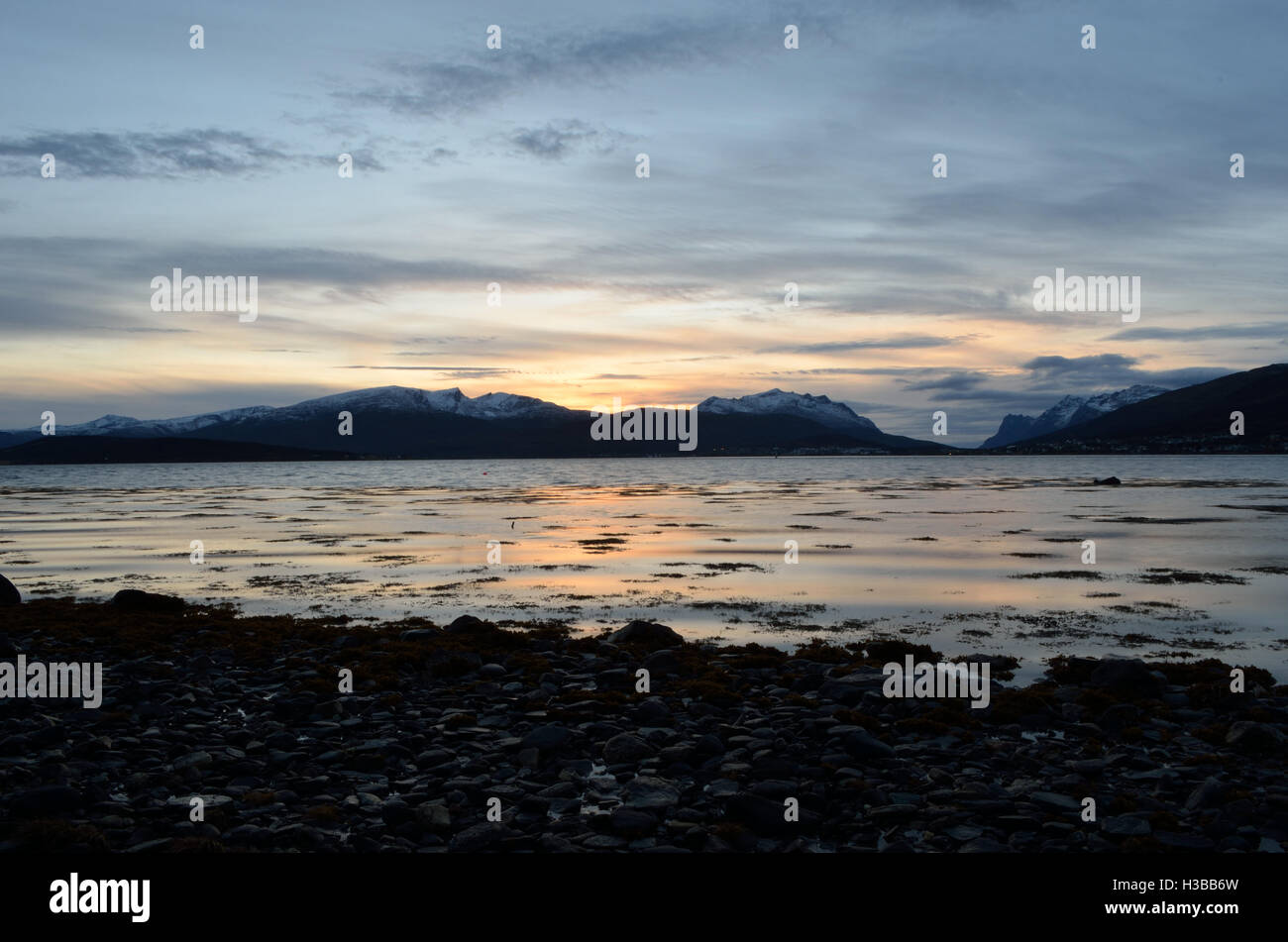 beautiful sunset over snowy mountain range and calm blue fjord Stock ...