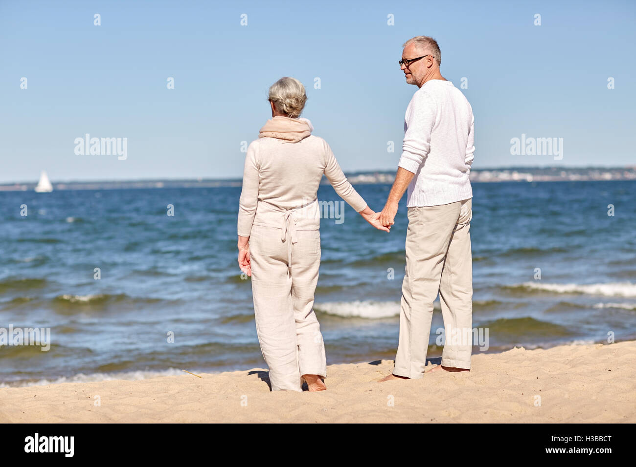 happy senior couple holding hands summer beach Stock Photo - Alamy