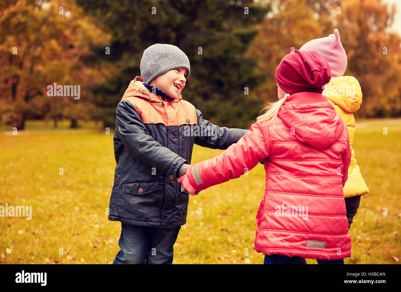 children holding hands and playing in autumn park Stock Photo - Alamy