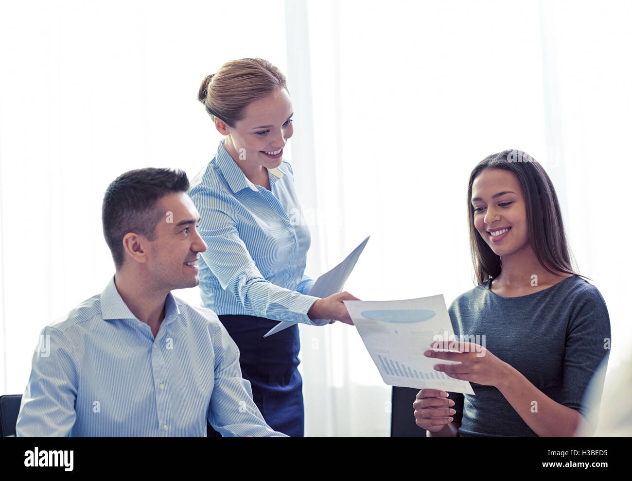 smiling business people with papers in office Stock Photo - Alamy