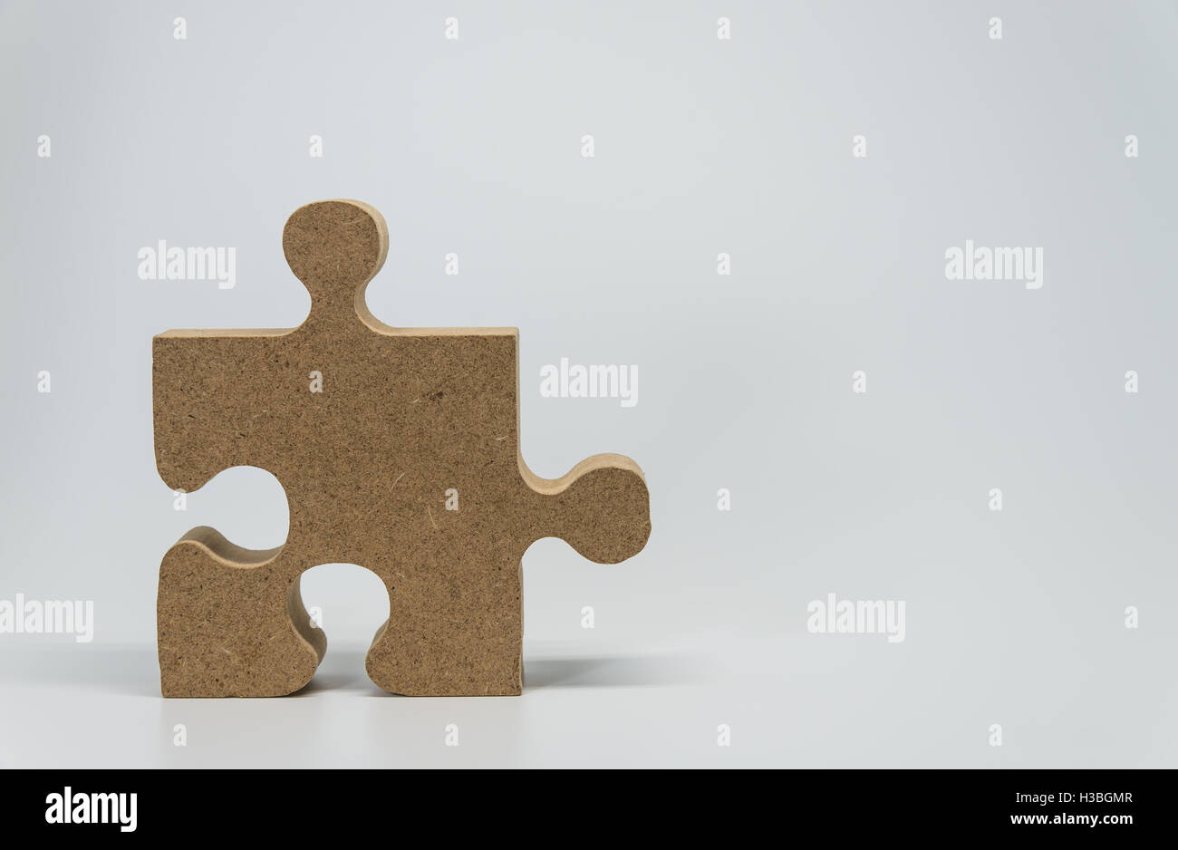 One Wooden piece of jigsaw puzzle with white background and selective ...