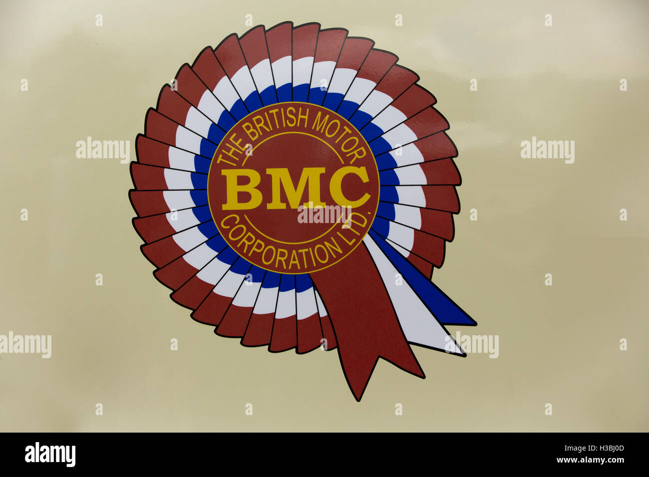 Iconic emblem of the British Motor Corporation. BMC. The brand disappeared in 1968 to become British Leyland. Distinct rosette on a beige background. Stock Photo