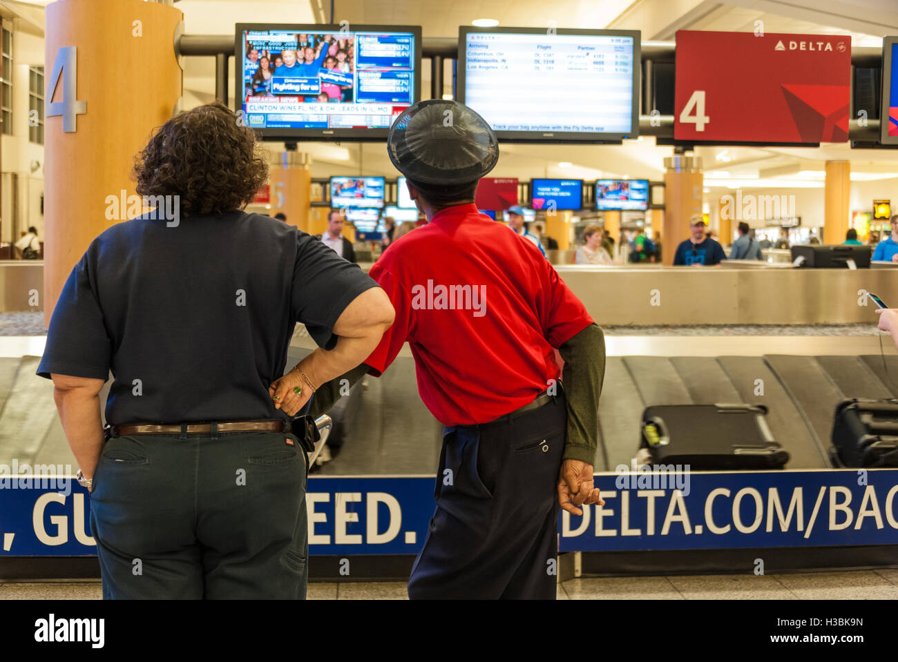 Atlanta Airport employees watch primary election results for Hillary Clinton presidential campaign from Delta baggage claim. Stock Photo