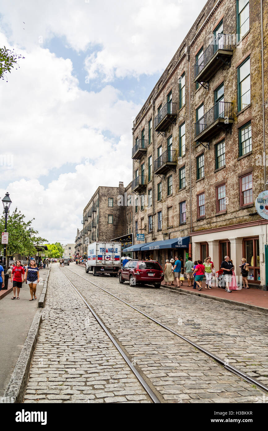 View of the shops down River Street in Savannah with trolley tracks in cobblestone street Stock Photo