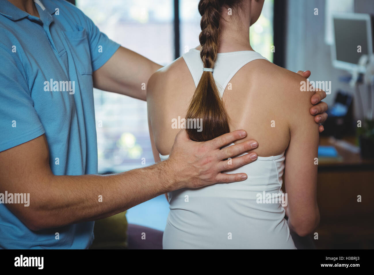 Physiotherapist massaging the back of a female patient Stock Photo