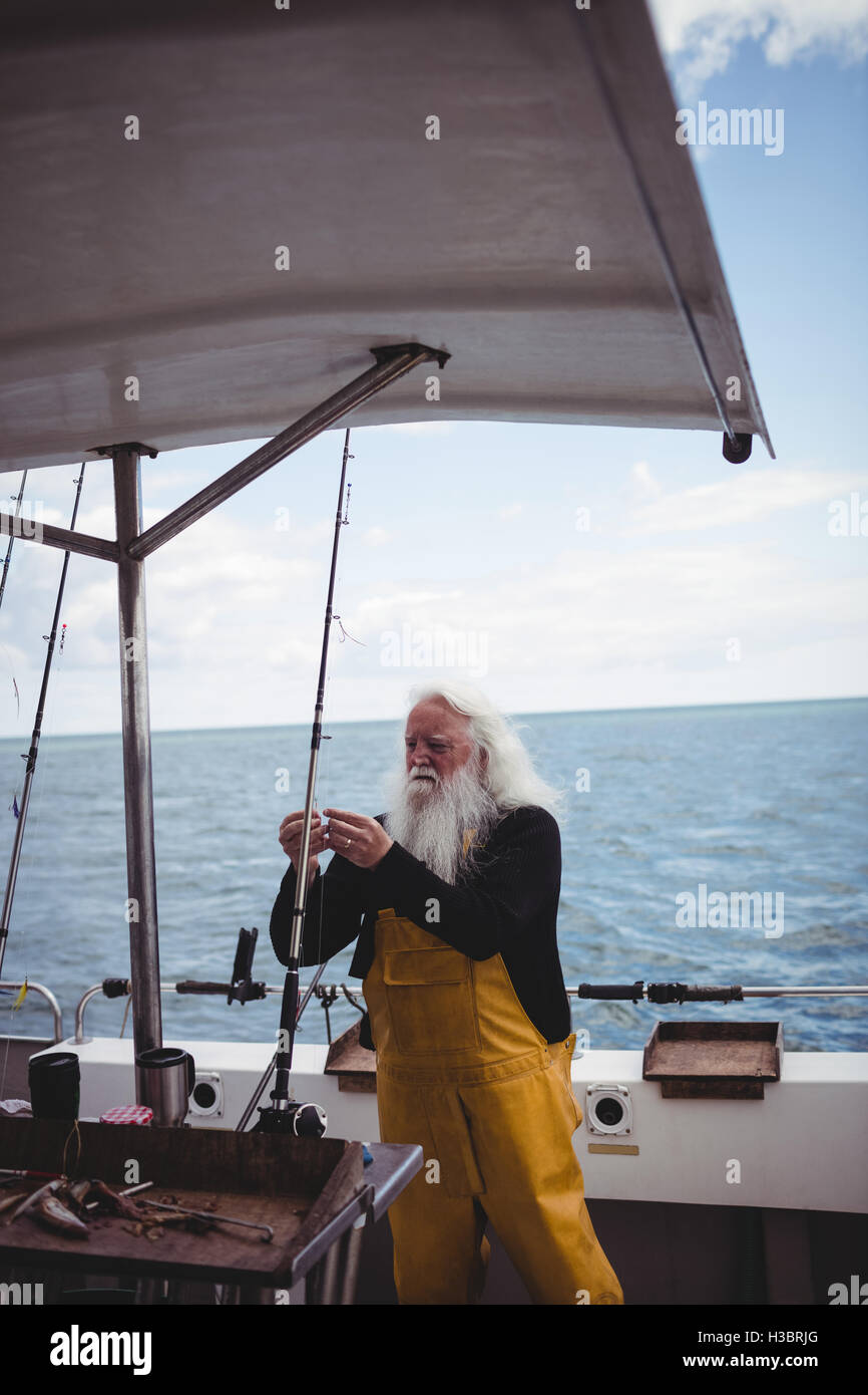 Fisherman adjusting fishing hook Stock Photo Alamy