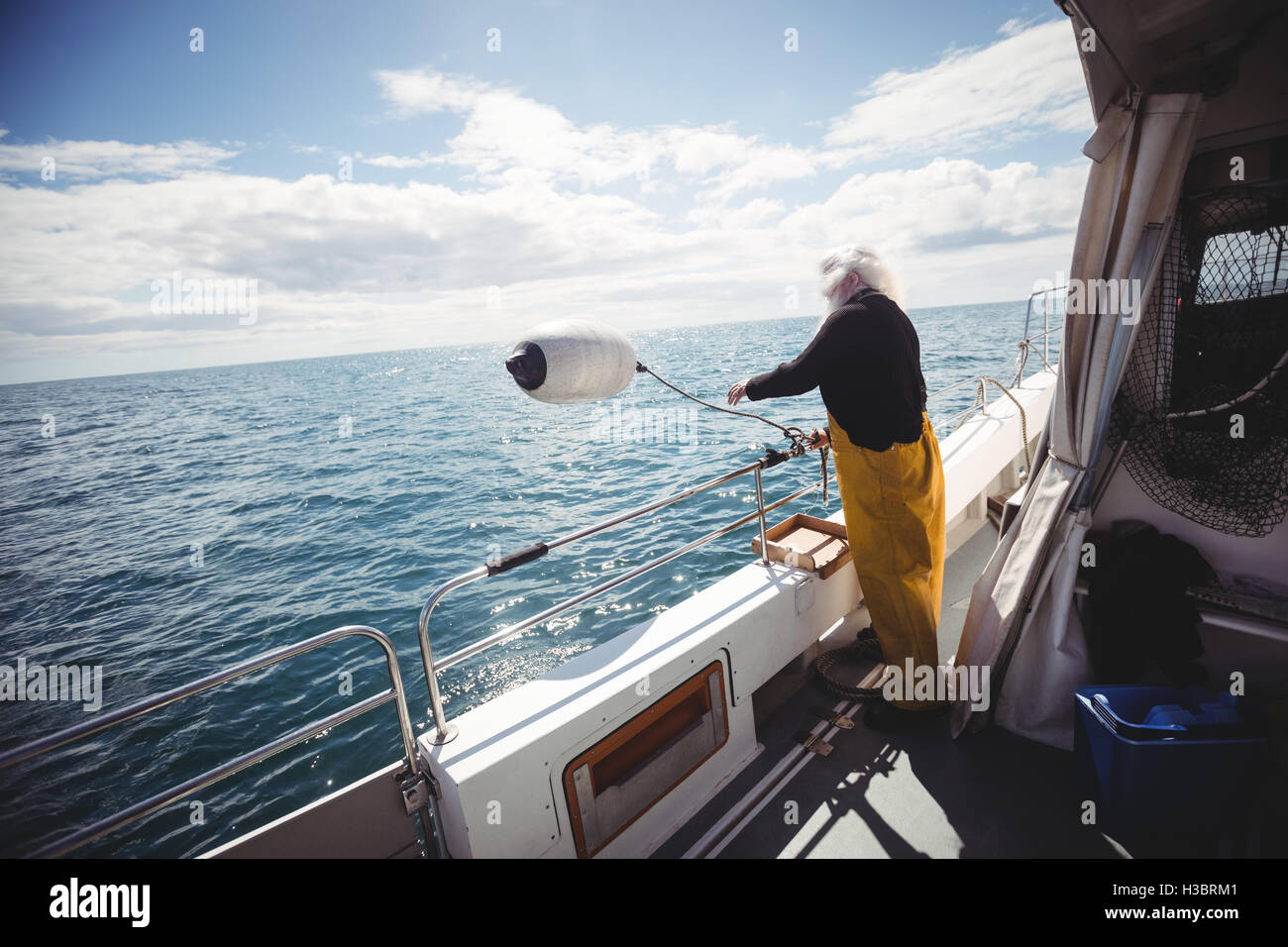 Fisherman throwing a buoy into the sea Stock Photo