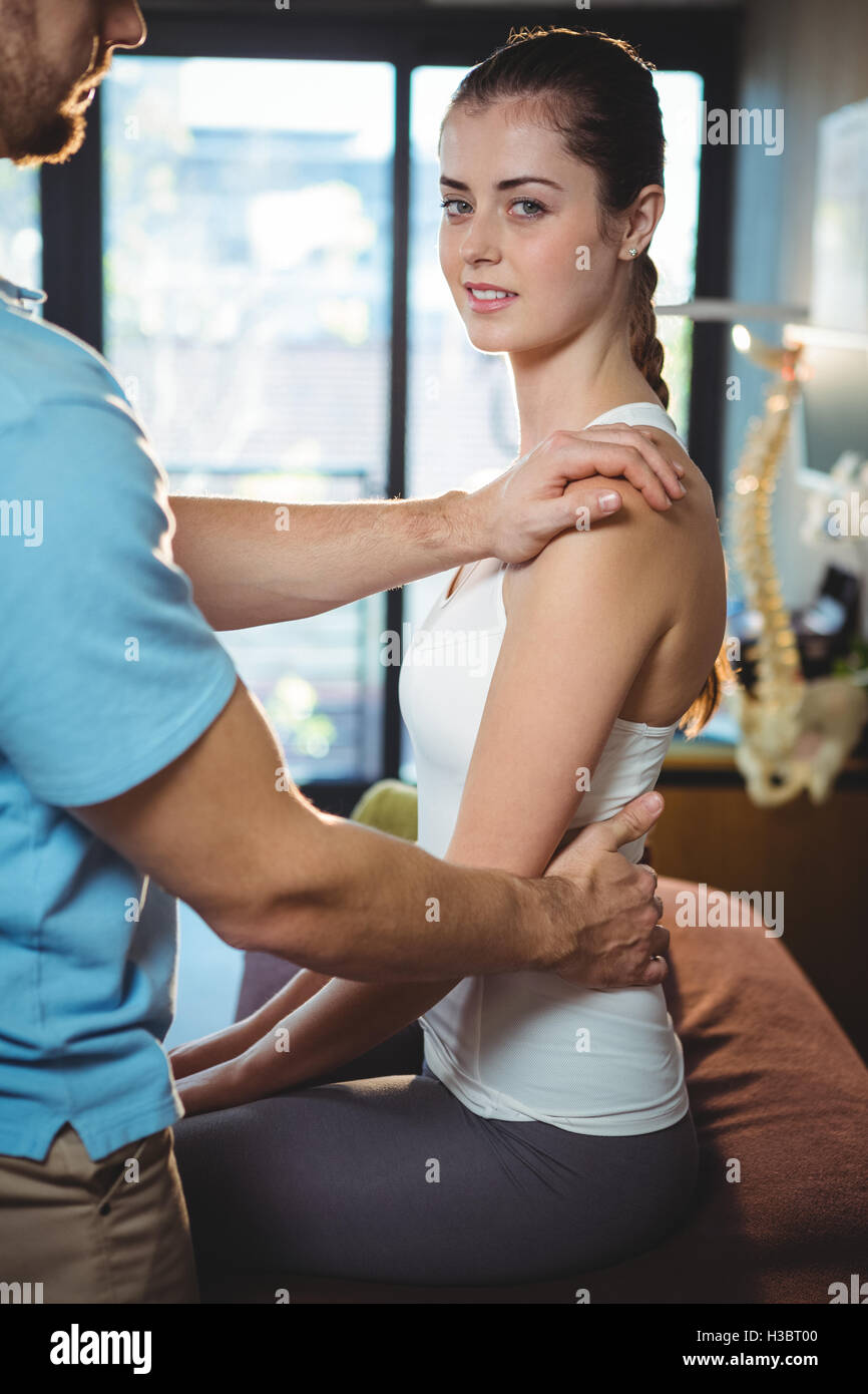Physiotherapist massaging the back of a female patient Stock Photo