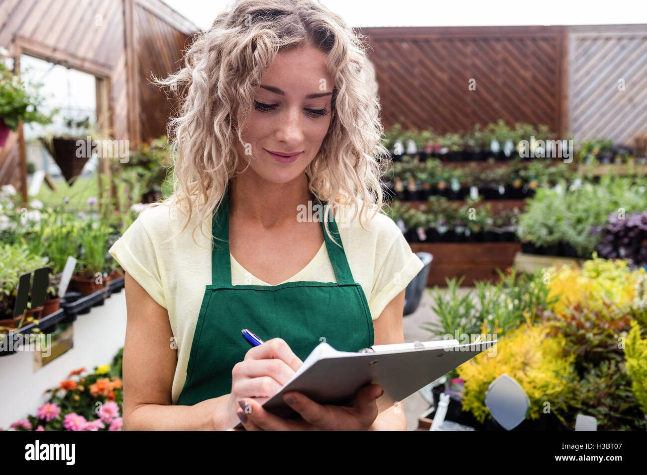 Female florist writing on clipboard Stock Photo