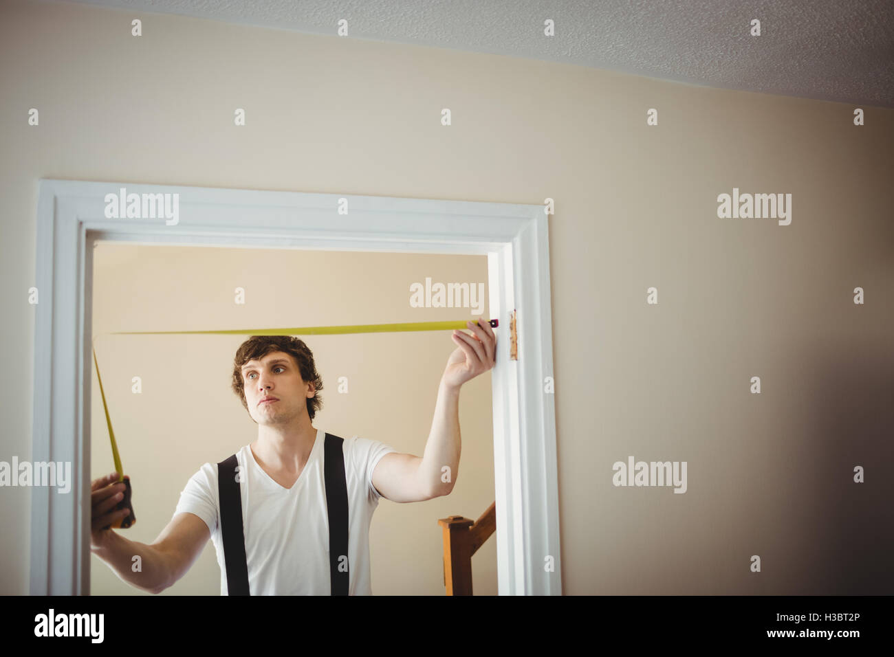 Carpenter measuring a door frame Stock Photo Alamy