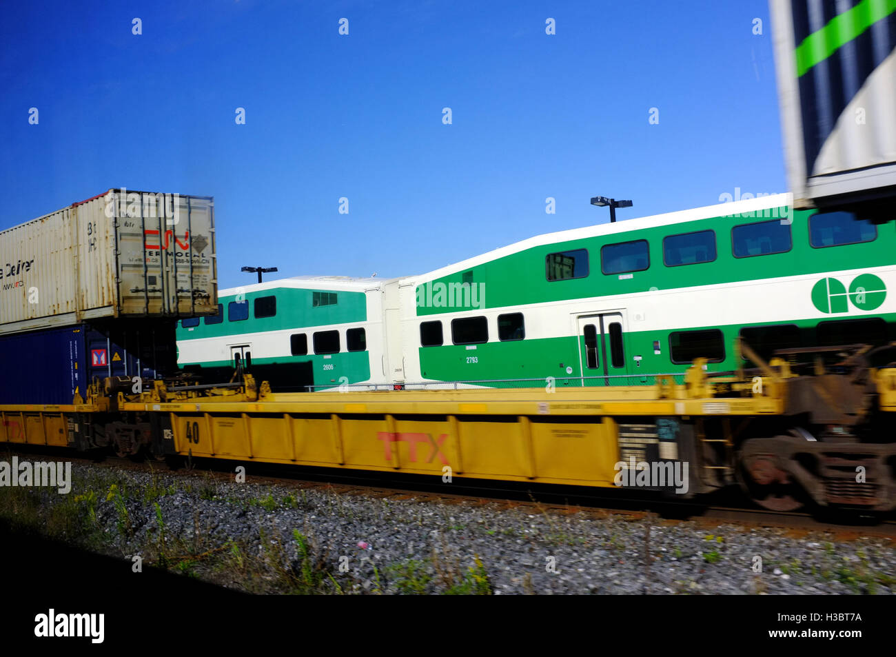 A freight train passing a double Decker passenger train in Ontario