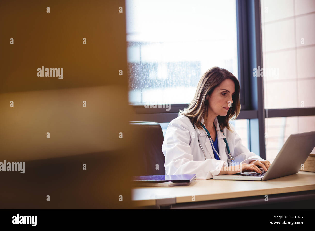 Female doctor using laptop at her desk Stock Photo