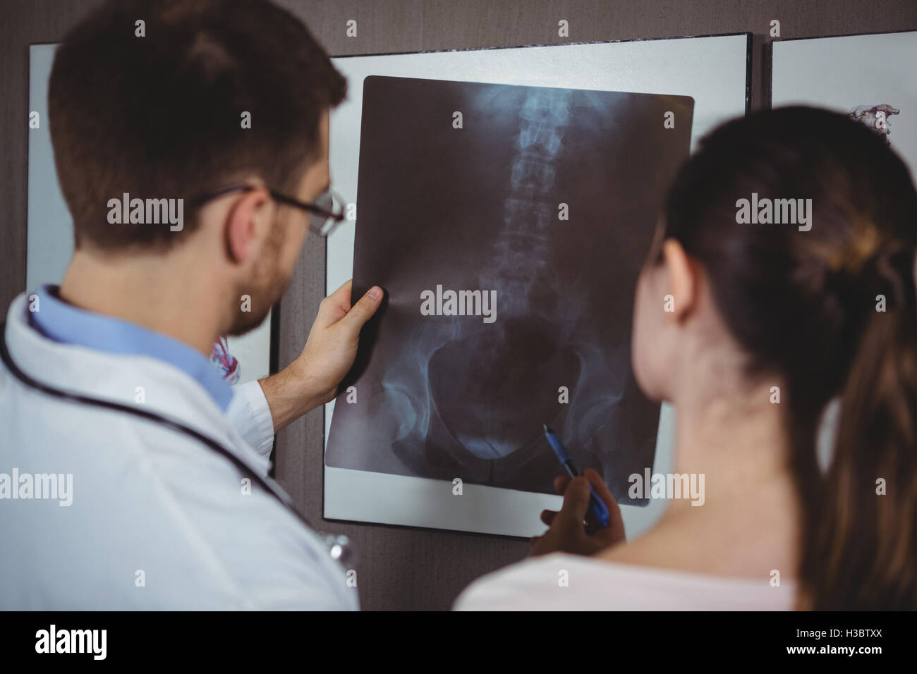 Physiotherapist explaining spine x-ray to female patient Stock Photo
