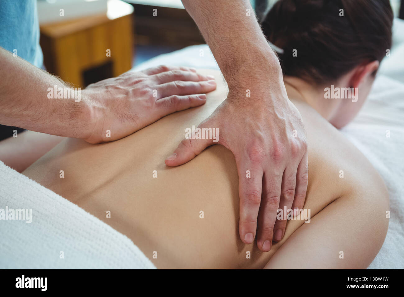 Physiotherapist giving physical therapy to the back of a female patient Stock Photo