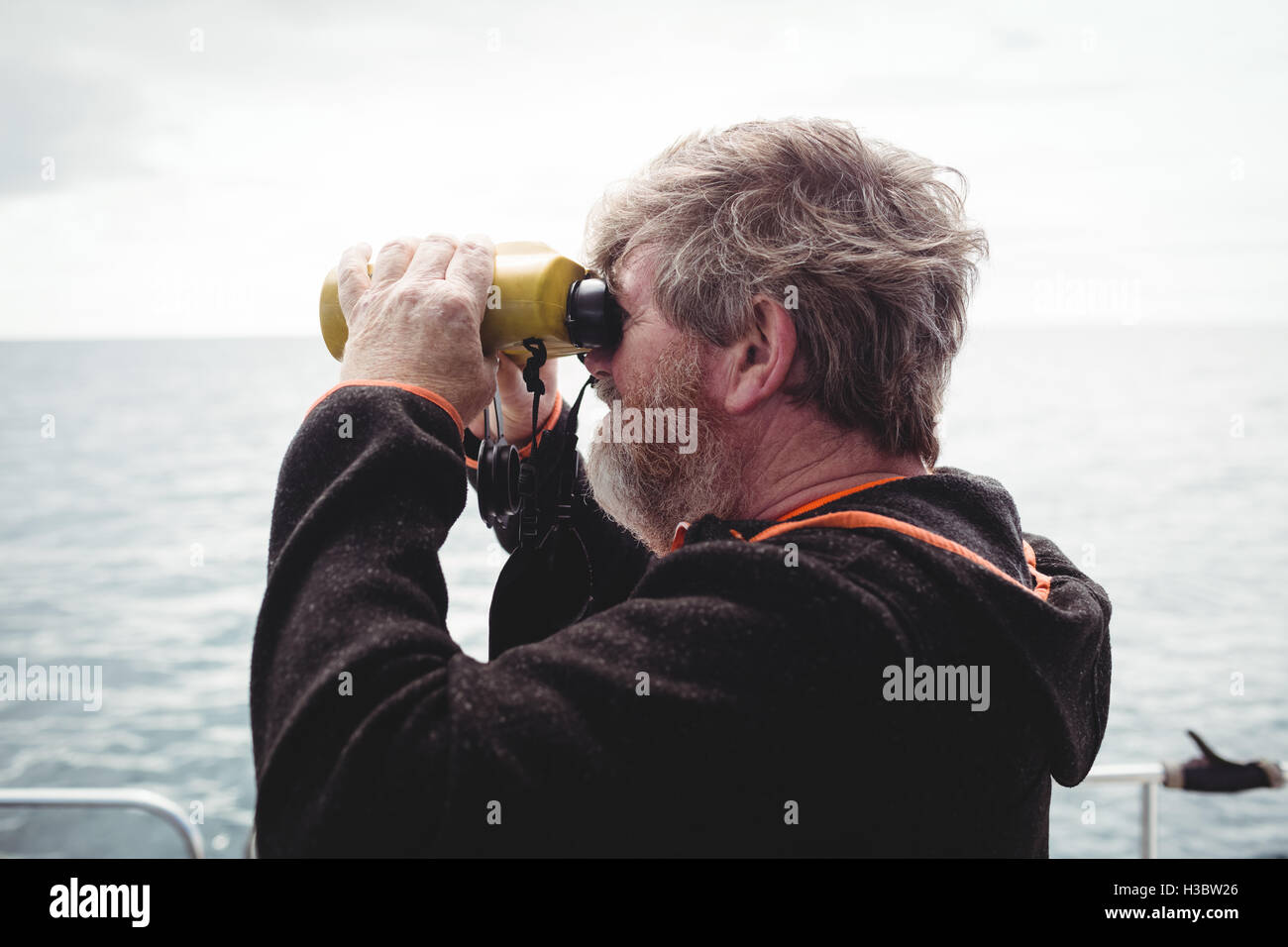 Fisherman looking through binoculars Stock Photo Alamy