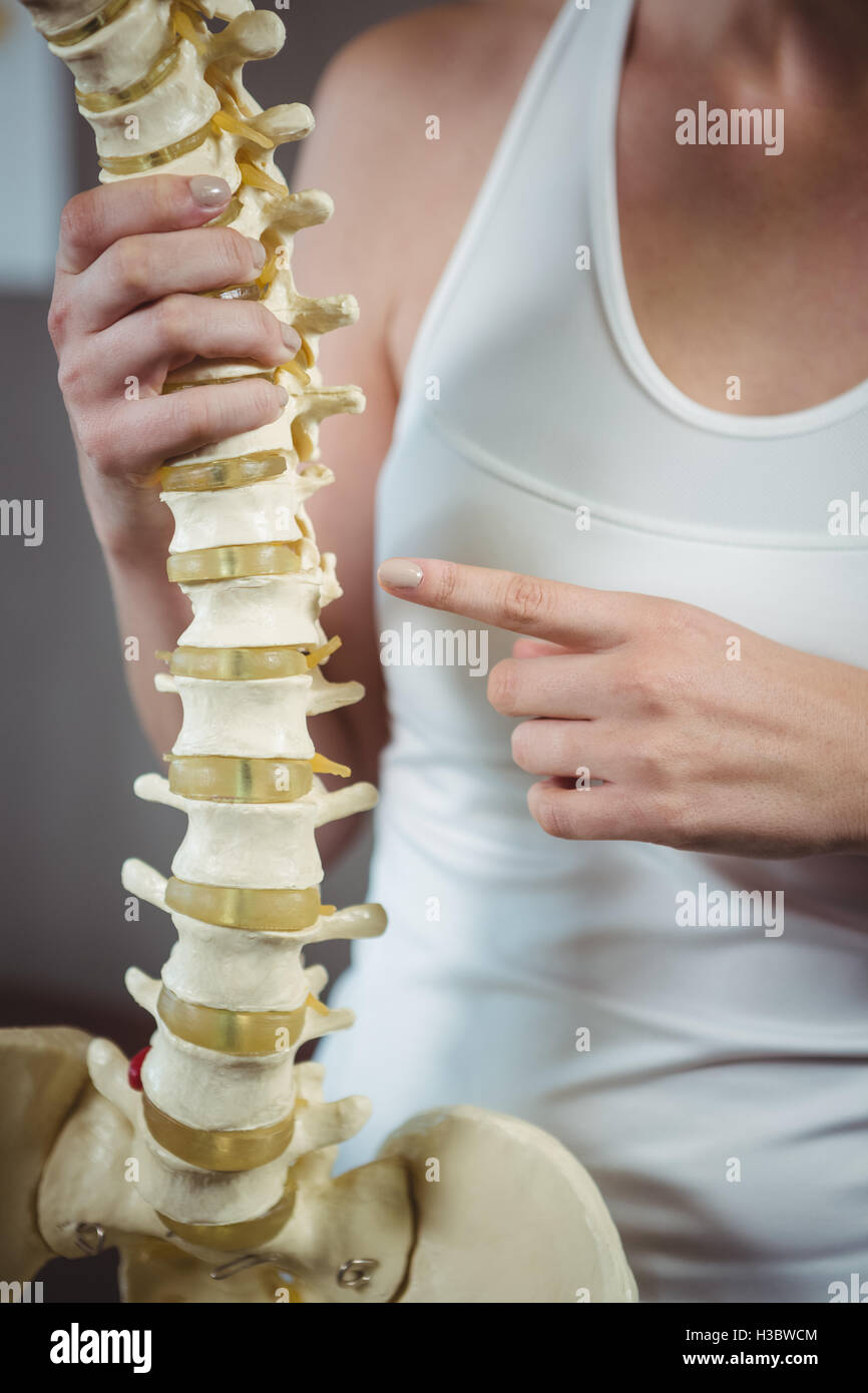 Female physiotherapist pointing at spine model Stock Photo