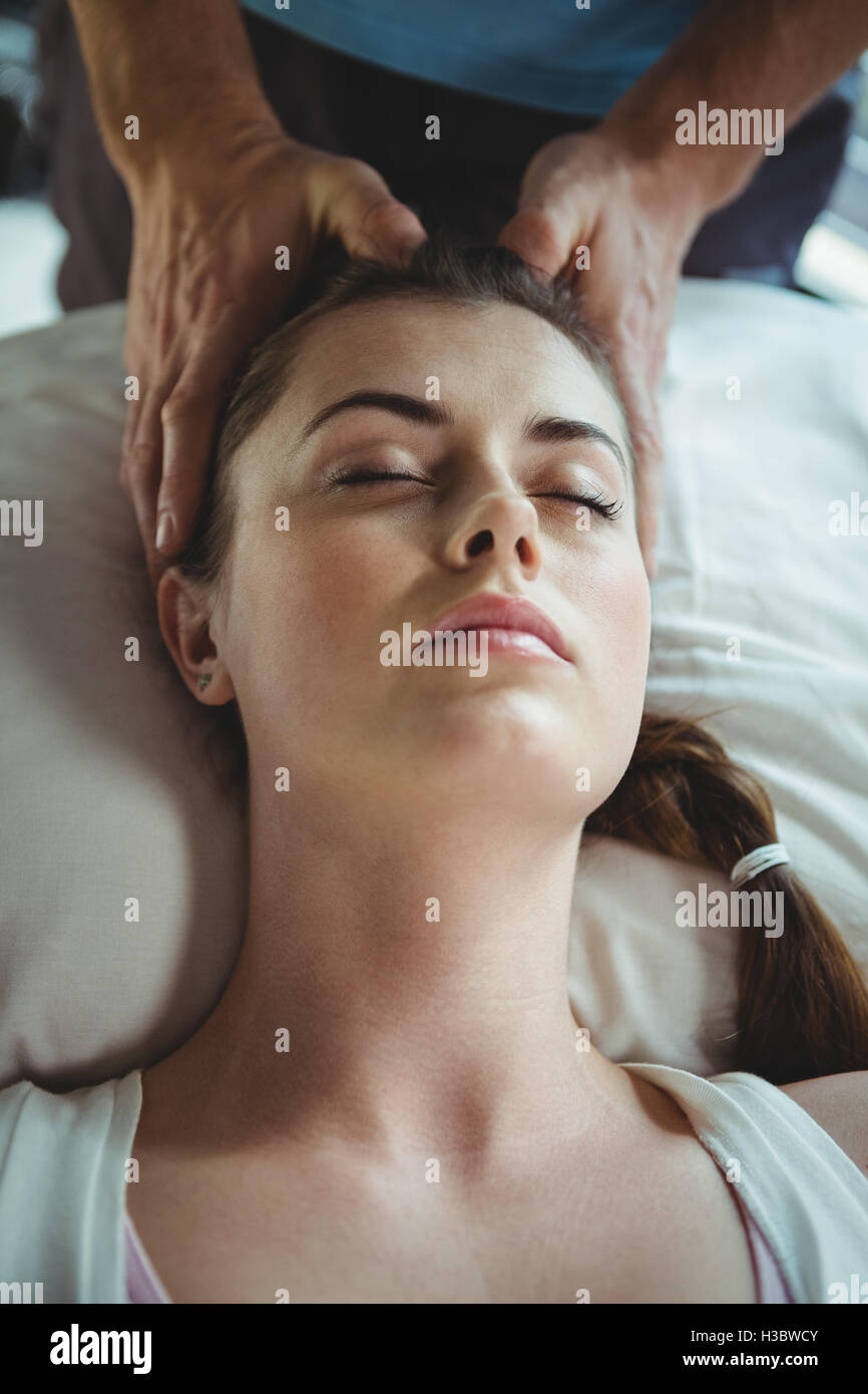 Male physiotherapist giving head massage to female patient Stock Photo