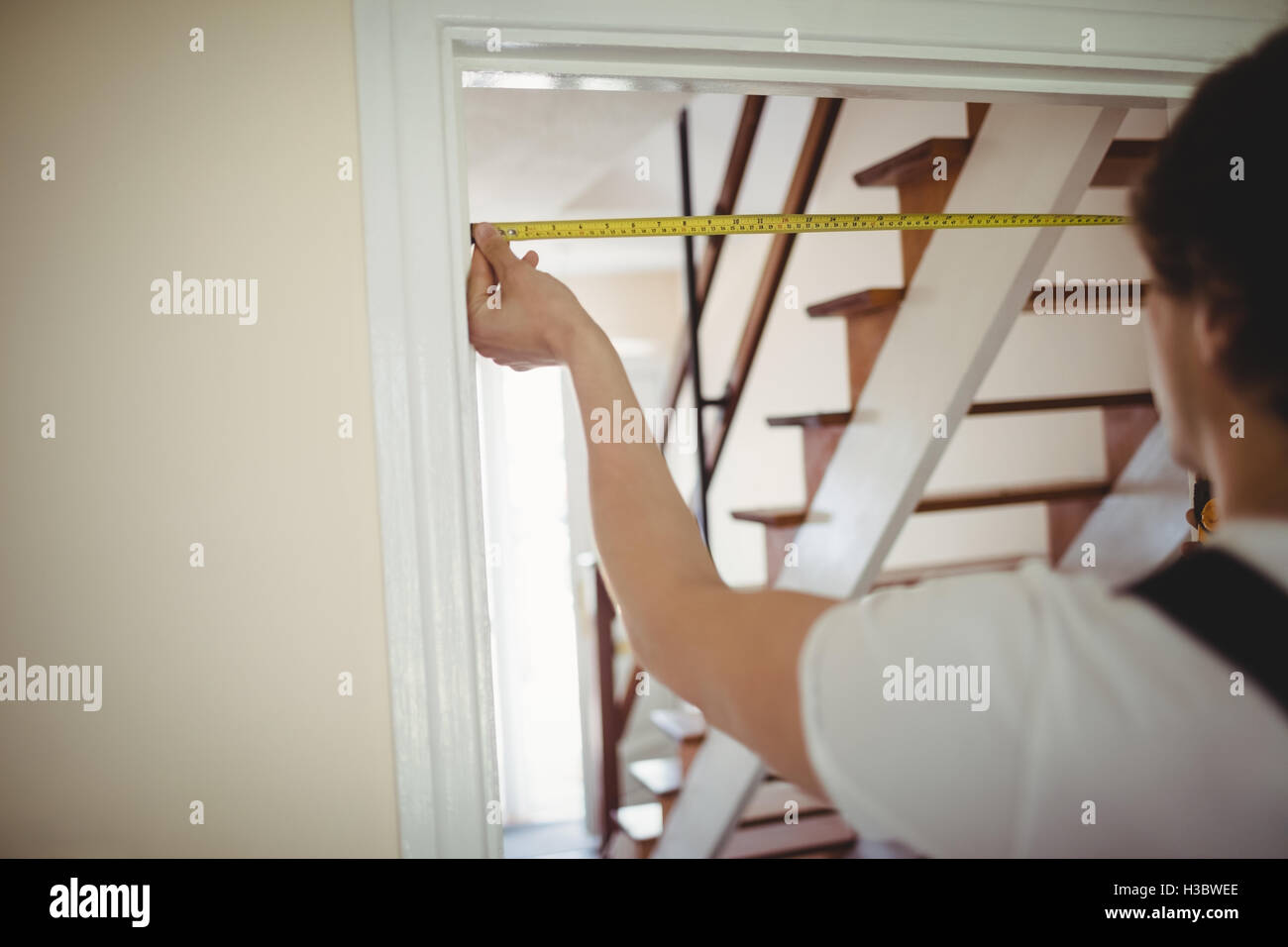Carpenter measuring a door frame Stock Photo Alamy