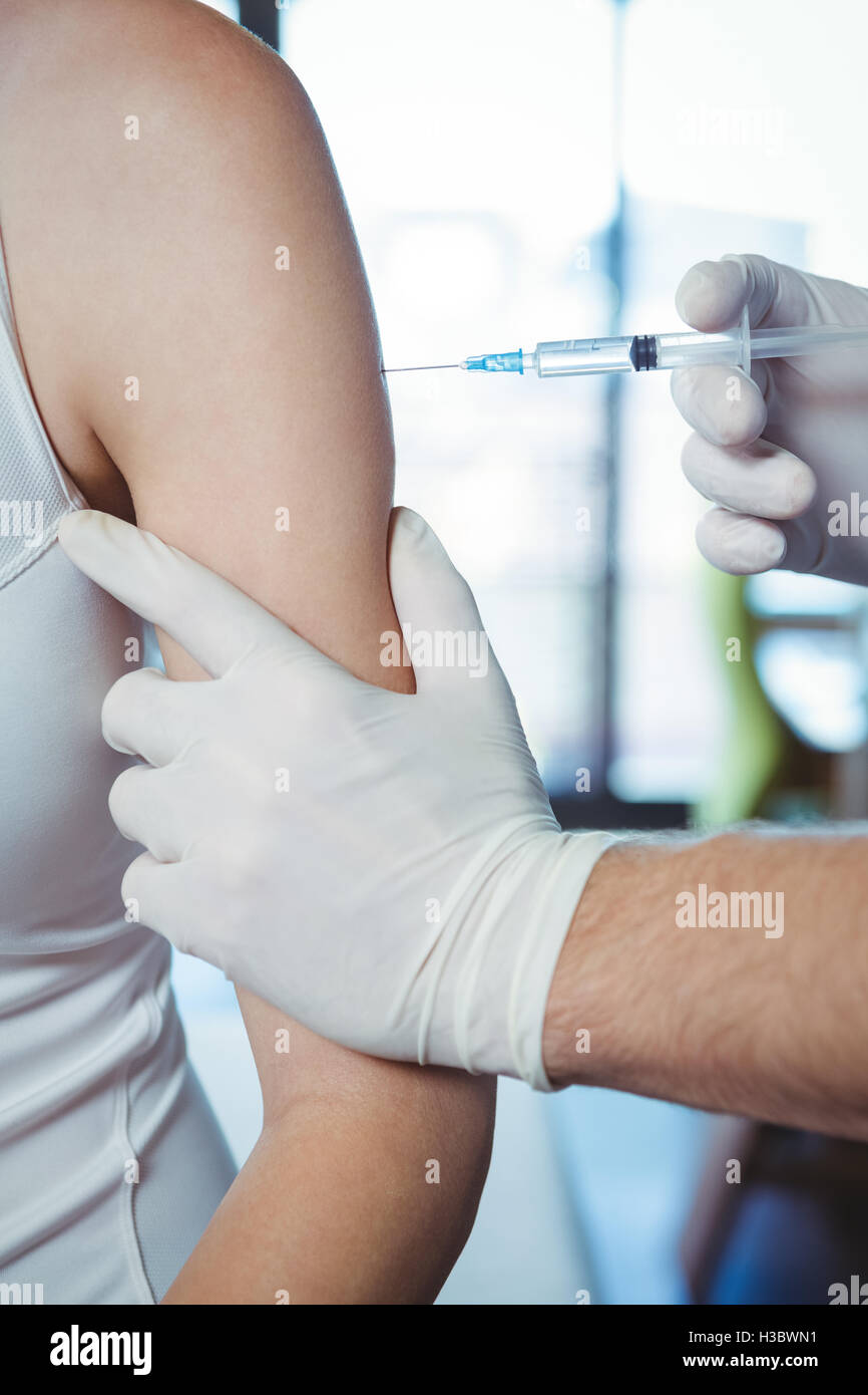 Male therapist injecting female patient Stock Photo