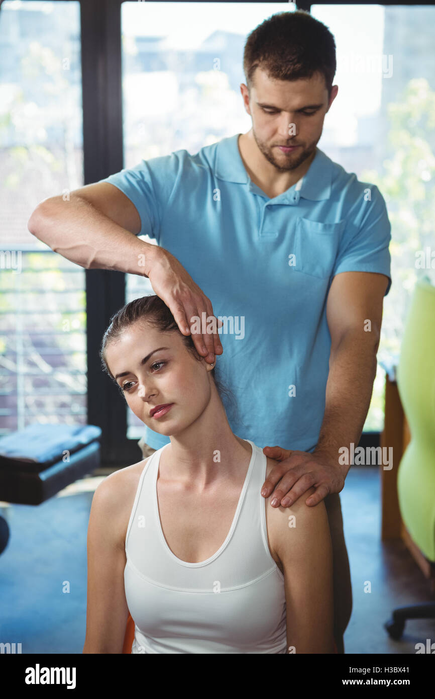 Physiotherapist stretching neck of a female patient Stock Photo