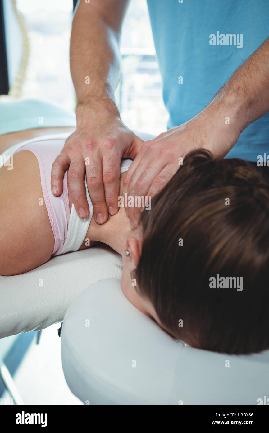 Physiotherapist giving physical therapy to the neck of a female patient Stock Photo
