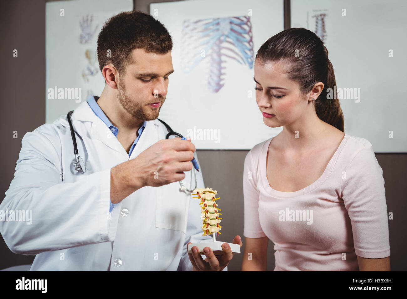 Physiotherapist explaining the spine to female patient Stock Photo