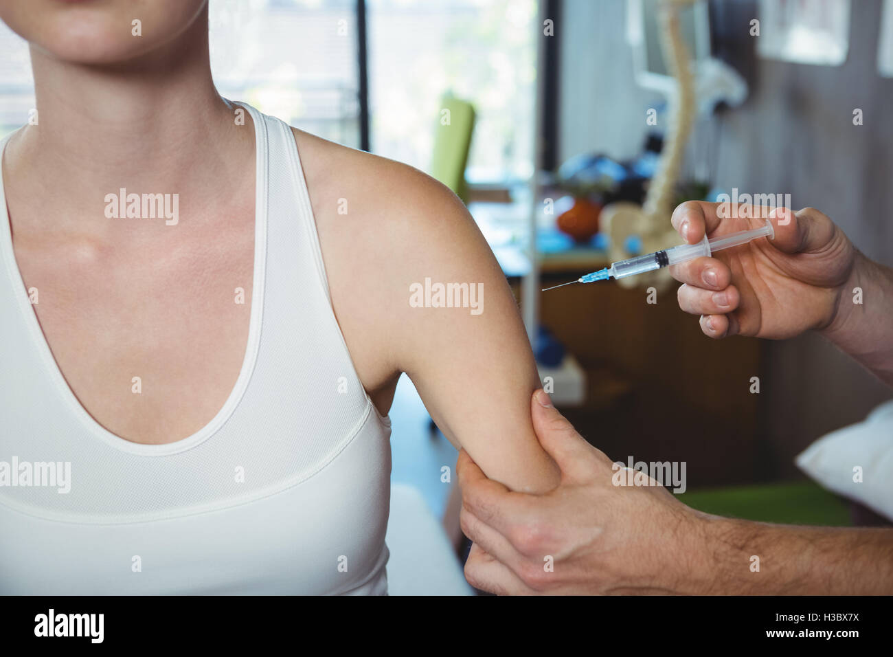 Male therapist injecting female patient Stock Photo