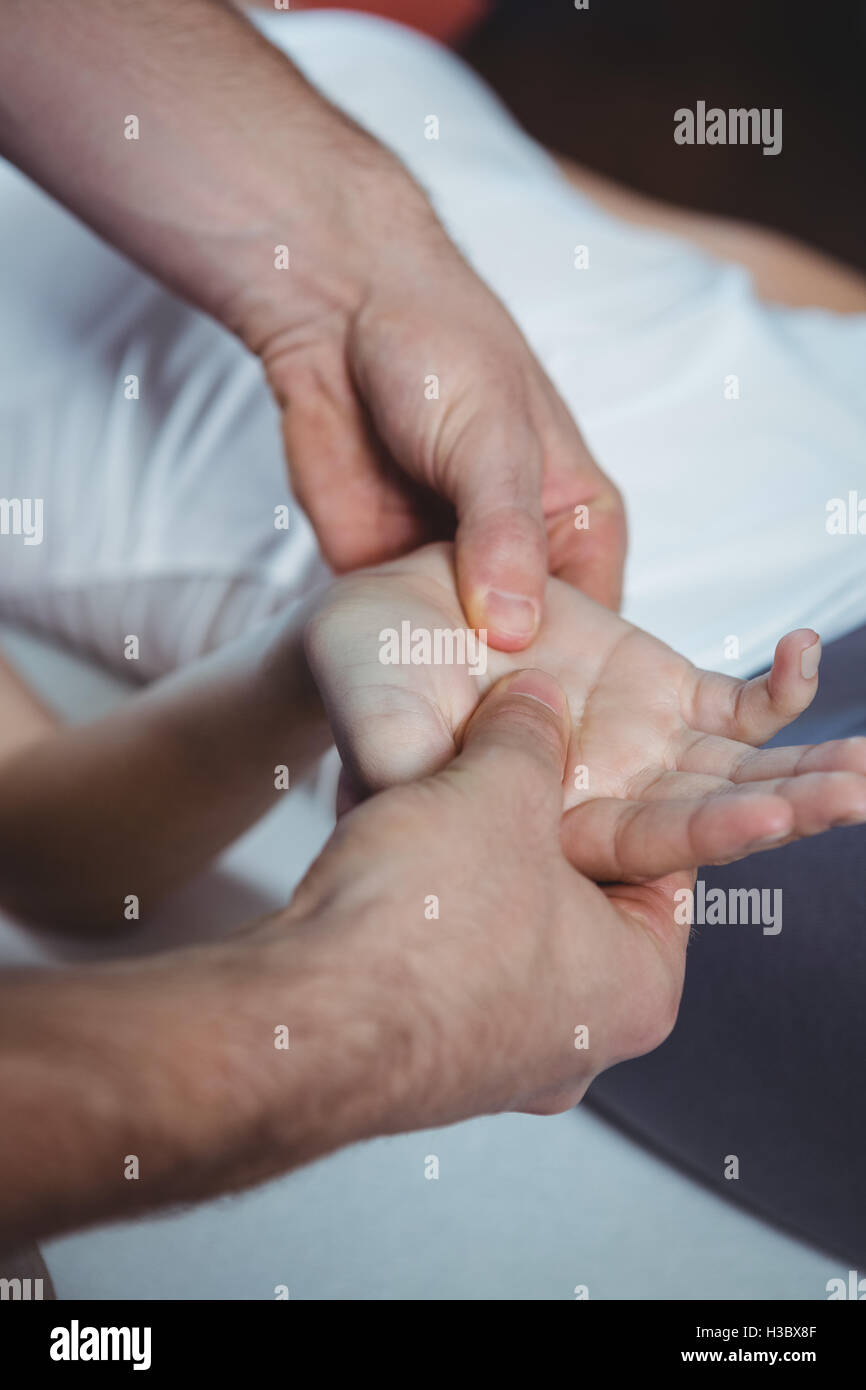 Physiotherapist massaging hand of a female patient Stock Photo