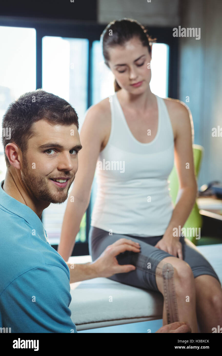 Male therapist measuring female patient knee with goniometer Stock Photo