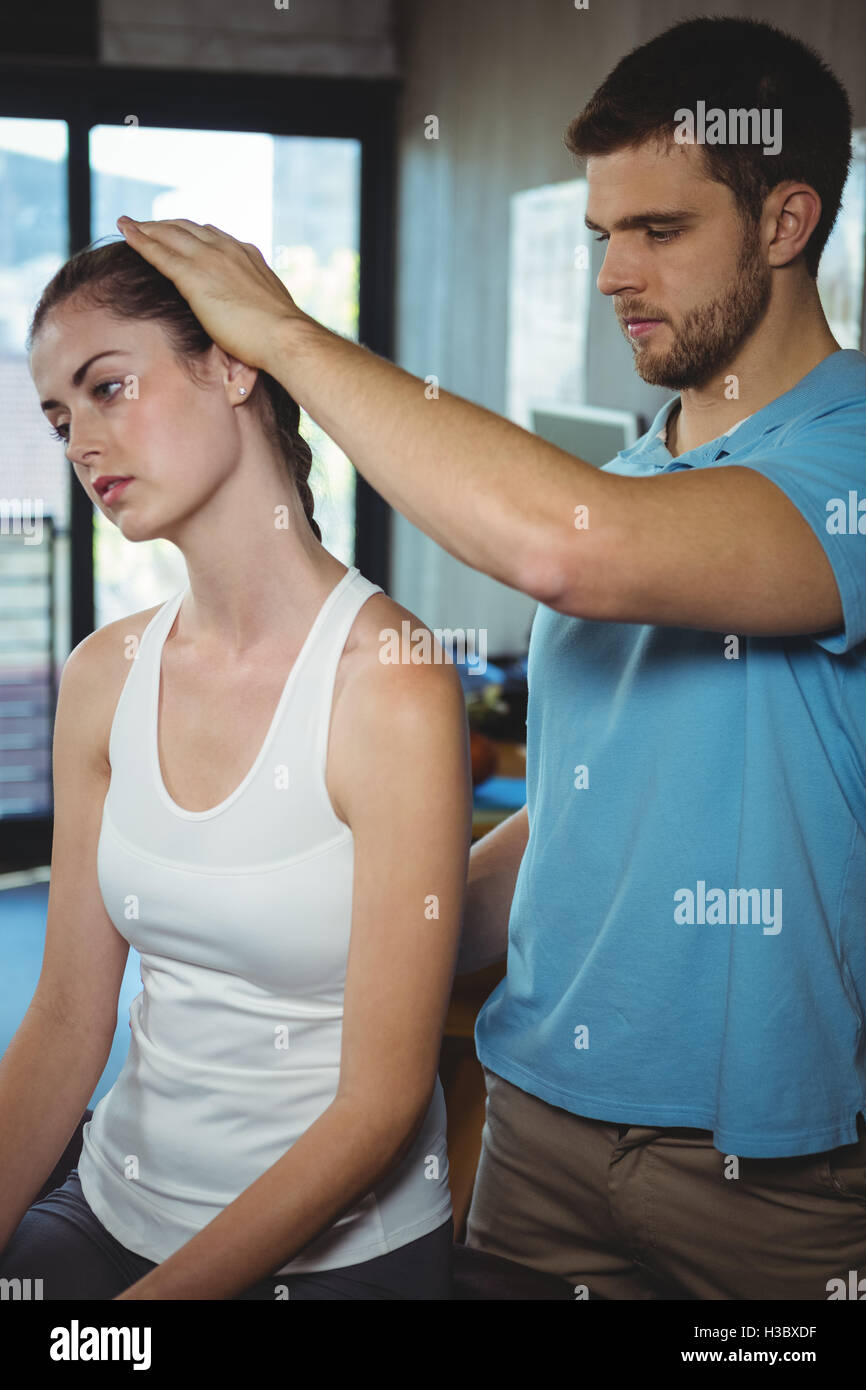 Physiotherapist stretching neck of a female patient Stock Photo