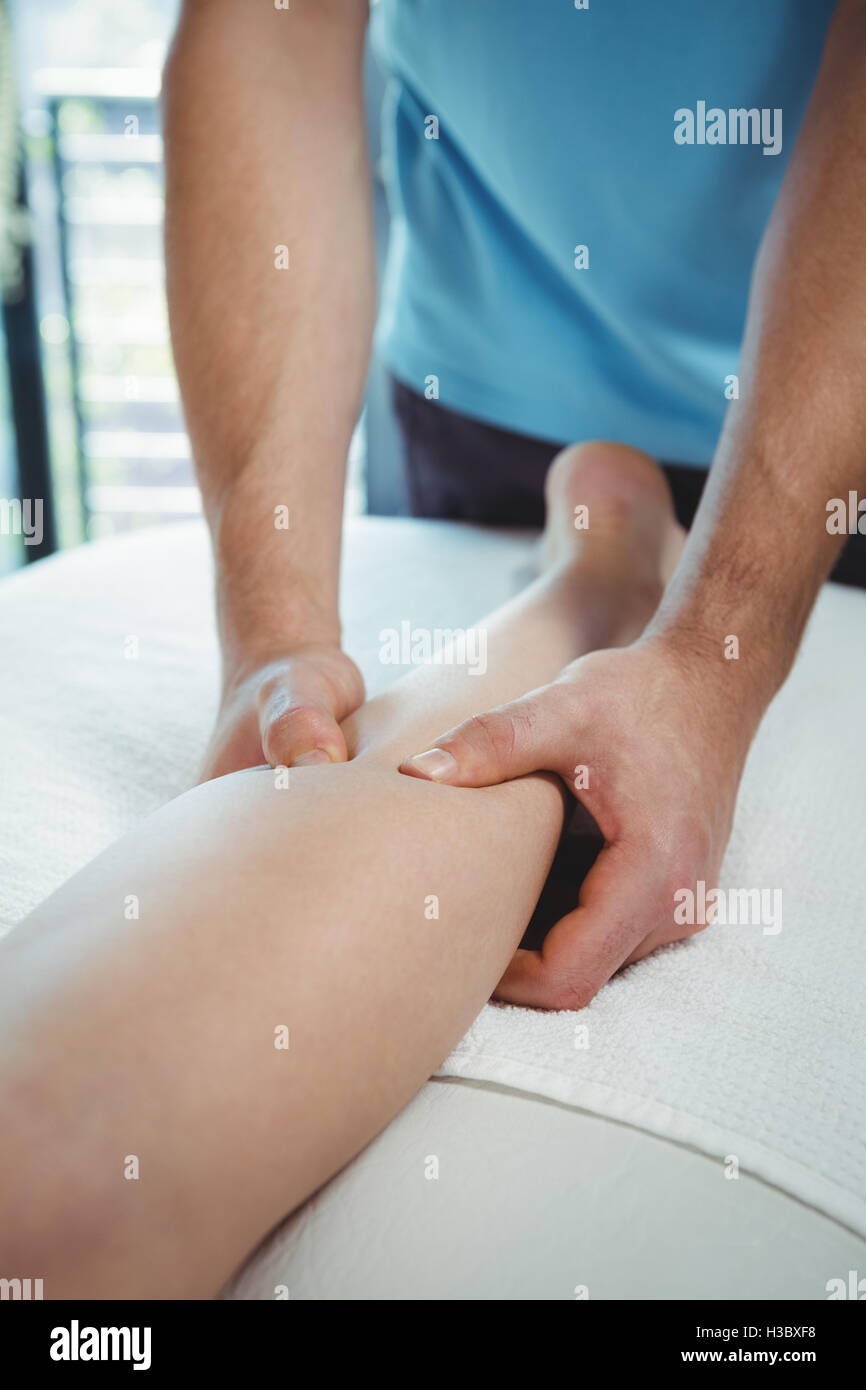 Physiotherapist giving physical therapy to the leg of a female patient Stock Photo