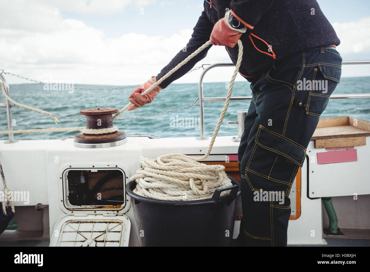 Fisherman tying rope on bollard Stock Photo - Alamy