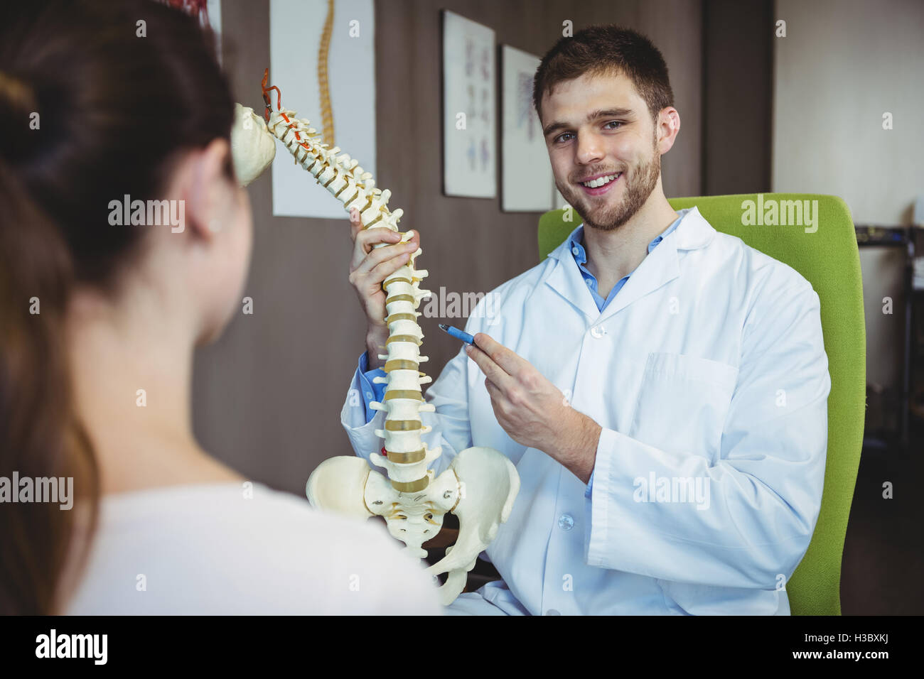 Physiotherapist explaining the spine to female patient Stock Photo