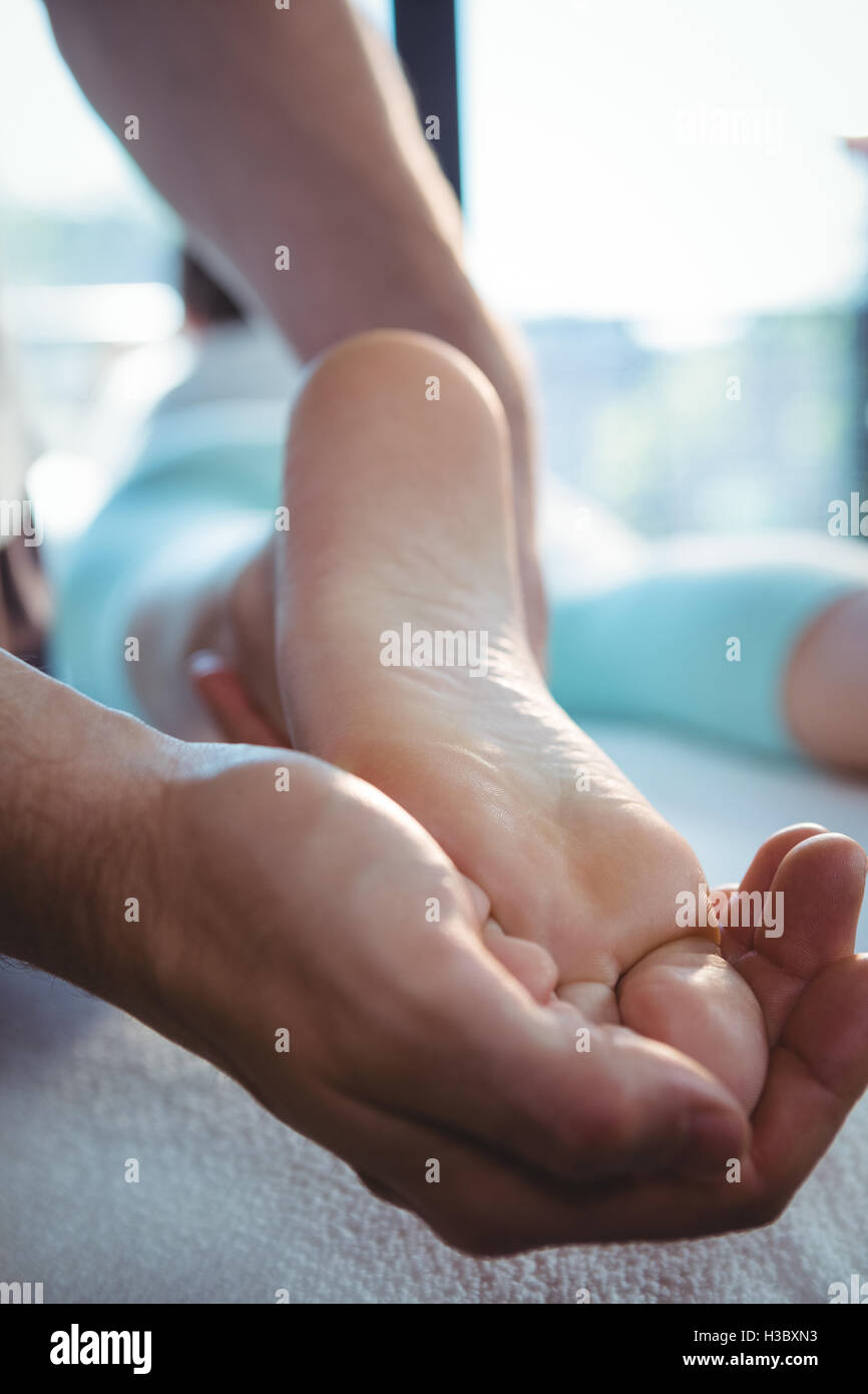 Male physiotherapist giving foot massage to female patient Stock Photo