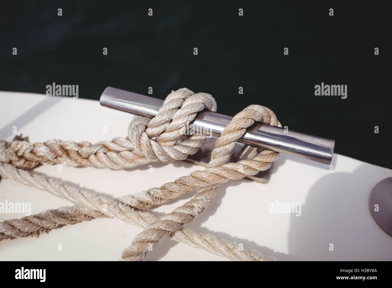 Rope tied to bollard on boat deck Stock Photo