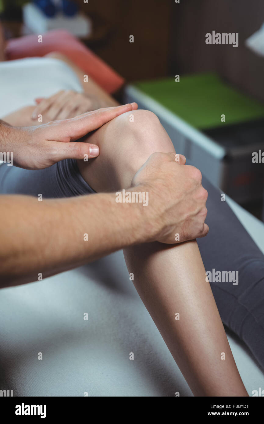 Physiotherapist giving physical therapy to the knee of a female patient Stock Photo