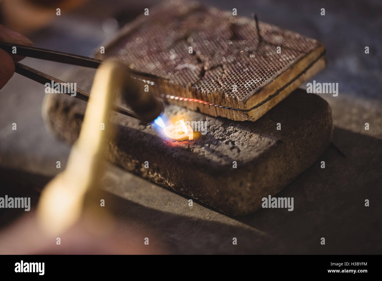 Goldsmith crafting ring by burner Stock Photo
